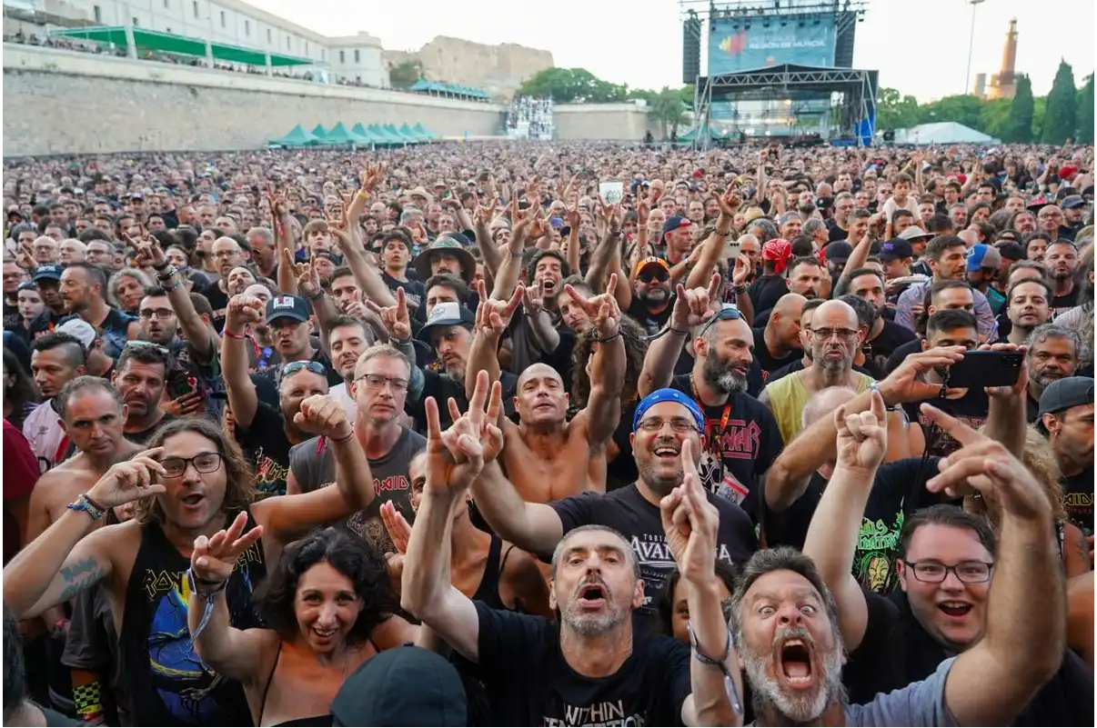 Miles de asistentes disfrutan del concierto de Iron Maiden en el Rock Imperium Festival de Cartagena, con el público levantando las manos frente al escenario principal en una imagen que refleja el gran ambiente del evento.