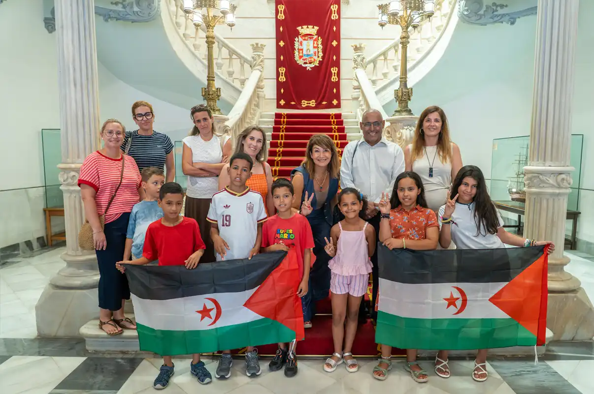 Foto de grupo de los niños saharauis del programa Vacaciones en Paz junto a la alcaldesa Noelia Arroyo, representantes de la Asociación Haima y las familias de acogida en el Palacio Consistorial de Cartagena.