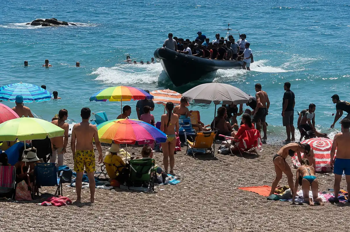 Patera con decenas de personas llegando a una cala de Cartagena ante la sorpresa de los bañistas que se encontraban en la playa.